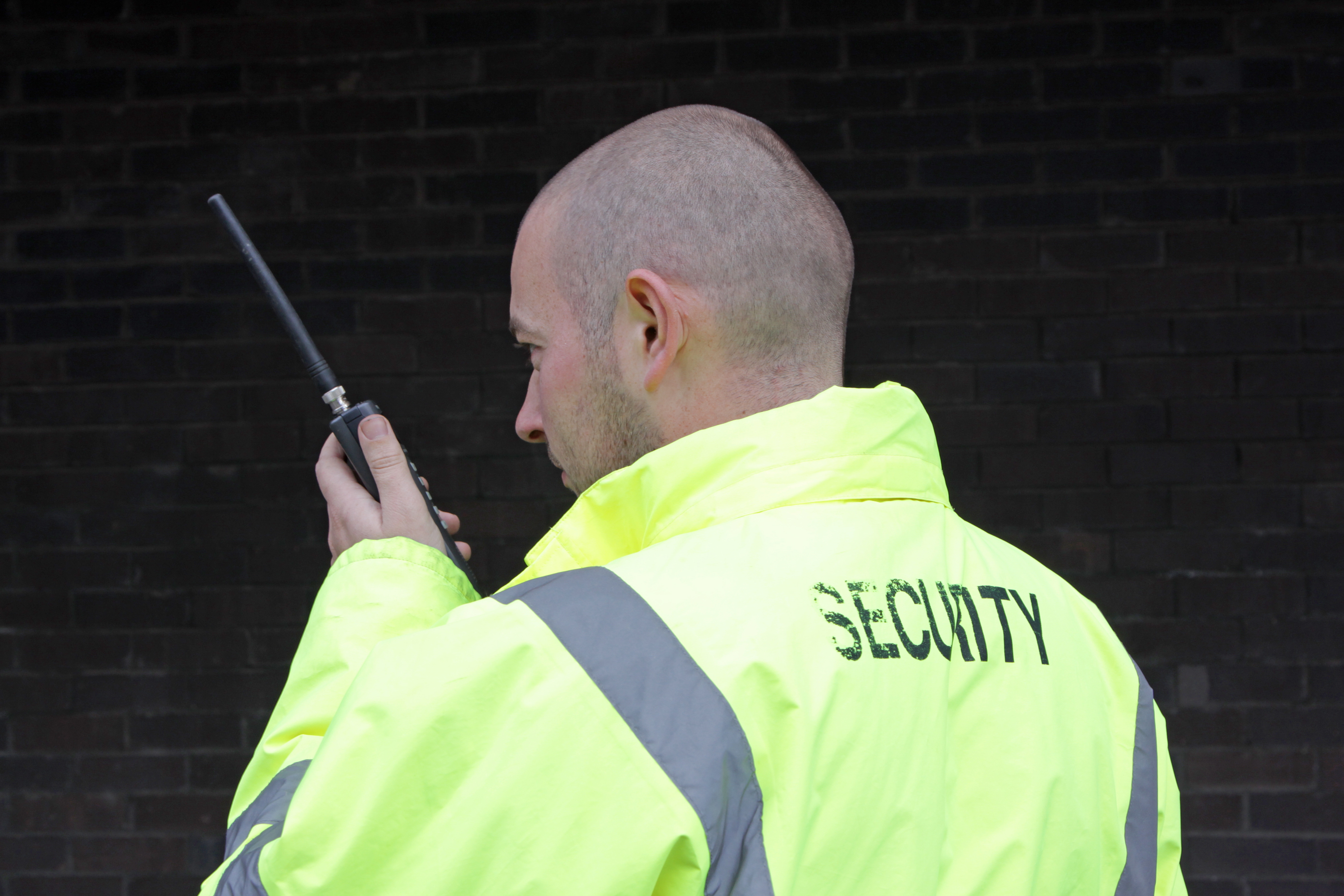 security officer using a walkie talkie to show the requirements for becoming a security officer